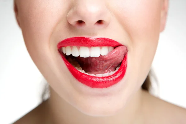 Woman licking teeth with tongue — Stock Photo, Image