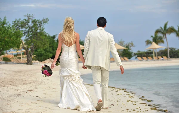 Newlyweds walking on beach together