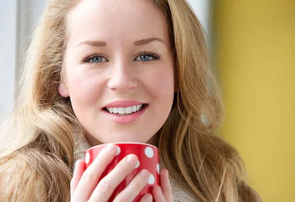 Mujer sonriente sosteniendo una taza de té — Foto de Stock