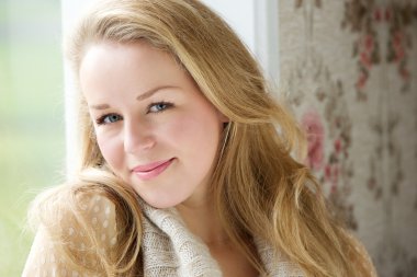 İçeride oturan ve kameraya bakarak genç kadın