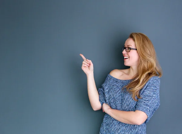 Smiling woman pointing finger — Stock Photo, Image