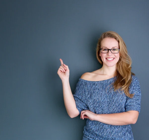 Lächelnde junge Frau zeigt mit dem Finger — Stockfoto