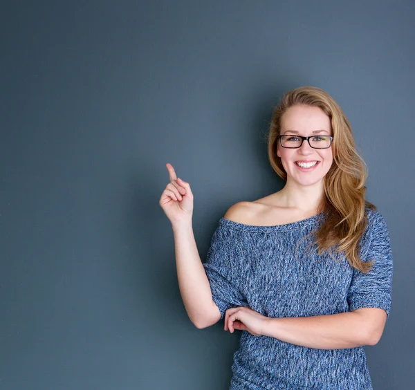 Smiling young woman pointing finger — Stock Photo, Image