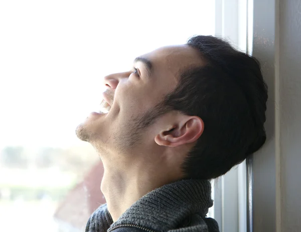 Jeune homme riant par la fenêtre — Photo