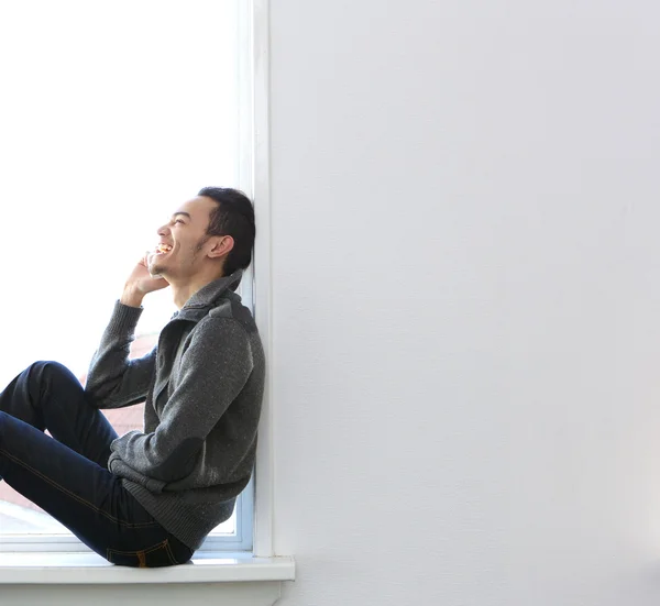 Mann sitzt am Fenster und telefoniert — Stockfoto