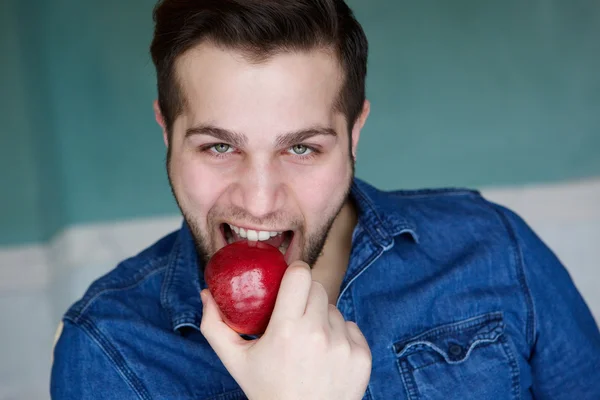 Mannen äter rött ekologiskt äpple — Stockfoto