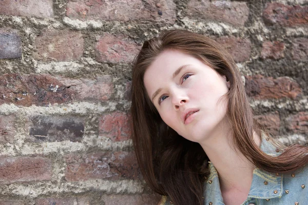 Model posing against brick wall — Stock Photo, Image