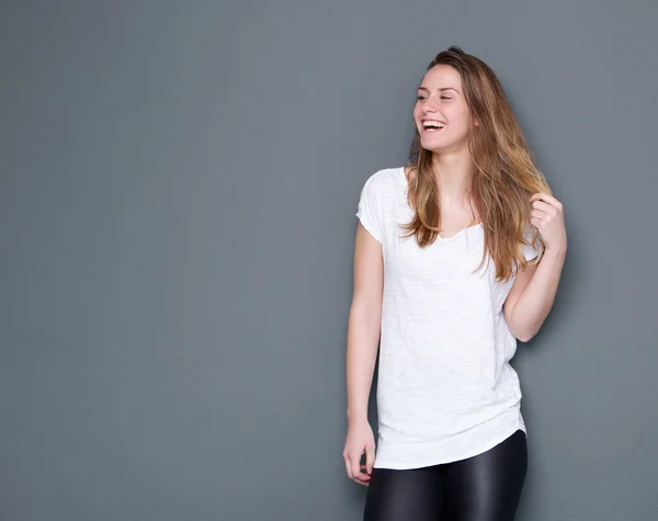 Jonge vrouw lachen met hand in haar — Stockfoto