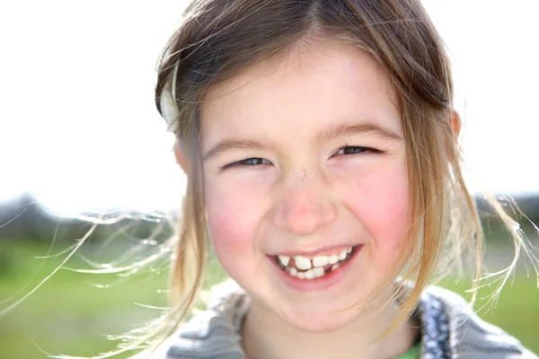 Cute young girl laughing outdoors — Stock Photo, Image