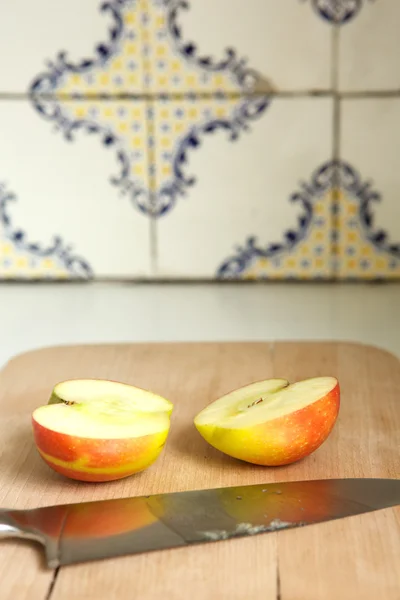 Apple sliced in half with kitchen — Stock Photo, Image