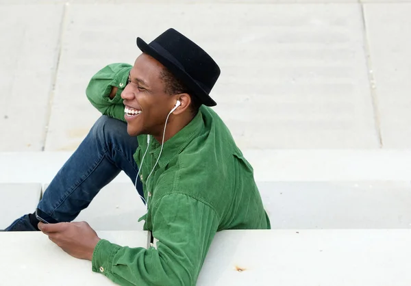 Man sitting outdoors listening to music — Stock Photo, Image