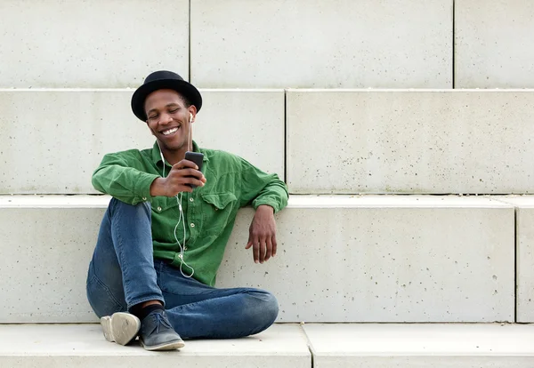 Homem sentado ao ar livre com telefone móvel — Fotografia de Stock
