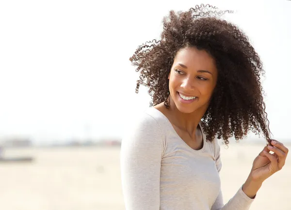 Mujer joven sonriendo con el pelo rizado — Foto de Stock