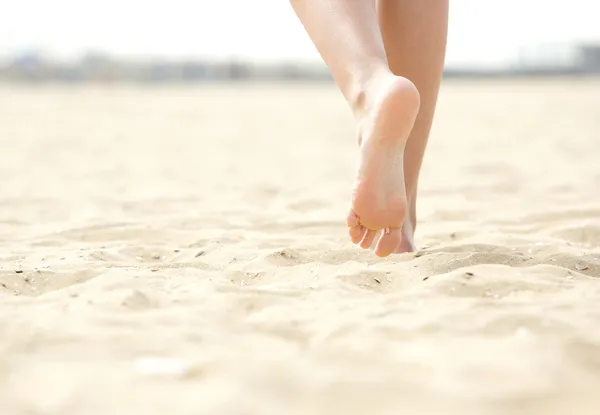 Frau läuft barfuß am Strand — Stockfoto