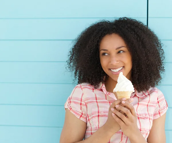 Mujer joven sonriendo y comiendo helado — Foto de Stock
