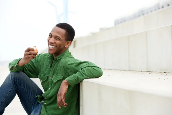 Jovem saudável sorrindo e comendo maçã — Fotografia de Stock