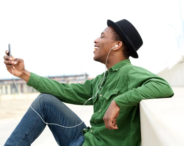 Jeune homme écoutant de la musique sur son téléphone portable — Photo