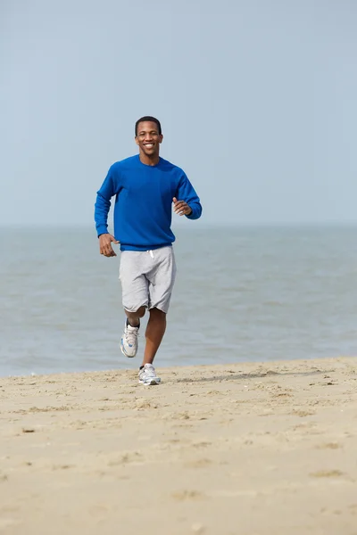 Joven saludable trotando en la playa — Foto de Stock