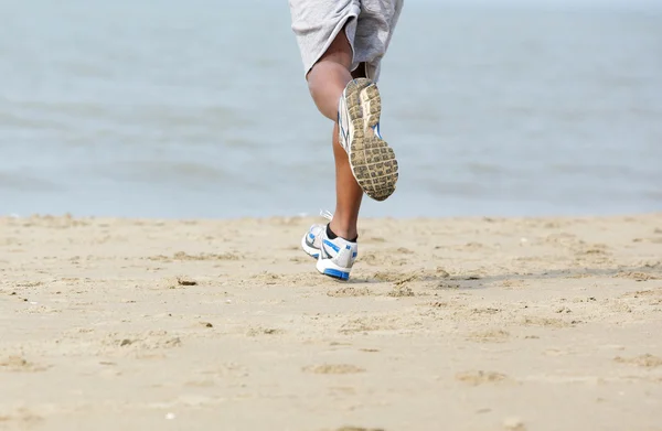 Vista posteriore jogger maschile in spiaggia — Foto Stock