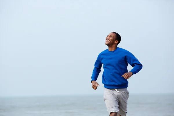 Atletische jongeman joggen buiten — Stockfoto