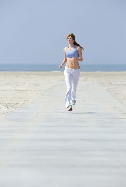 Frau joggt am Strand — Stockfoto