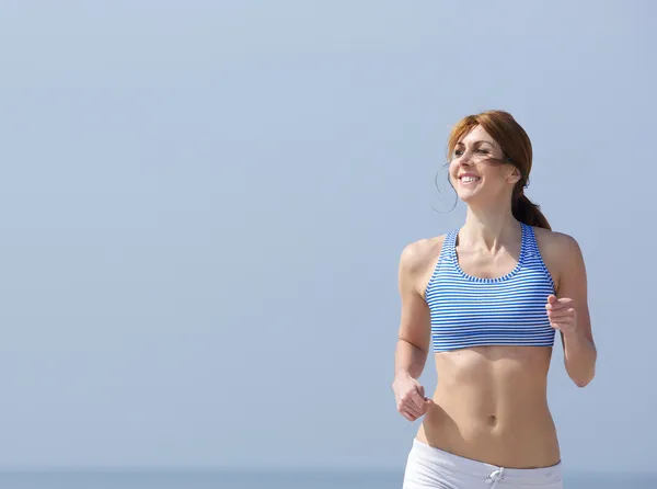 Sorridente donna che fa jogging all'aperto — Foto Stock