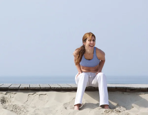 Женщина средних лет смеется над пляжем — стоковое фото
