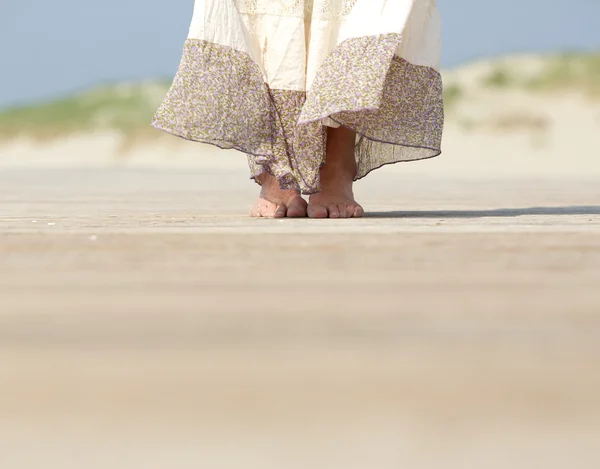 Piedi femminili in piedi sulla spiaggia — Foto Stock