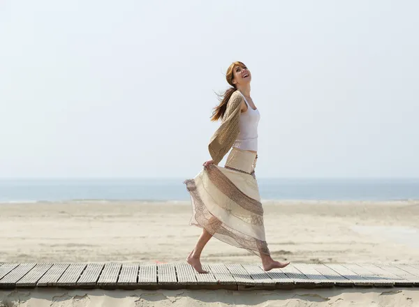 Carefree middle aged woman walking barefoot — Stock Photo, Image