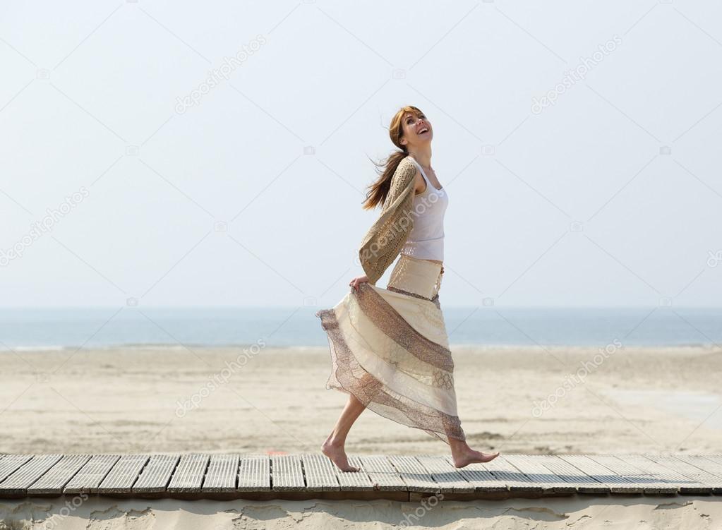 Carefree middle aged woman walking barefoot 