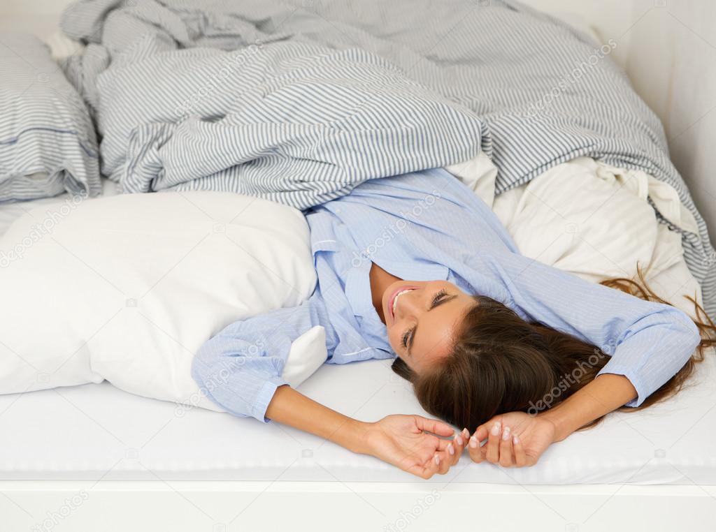 Young woman awake in bed smiling