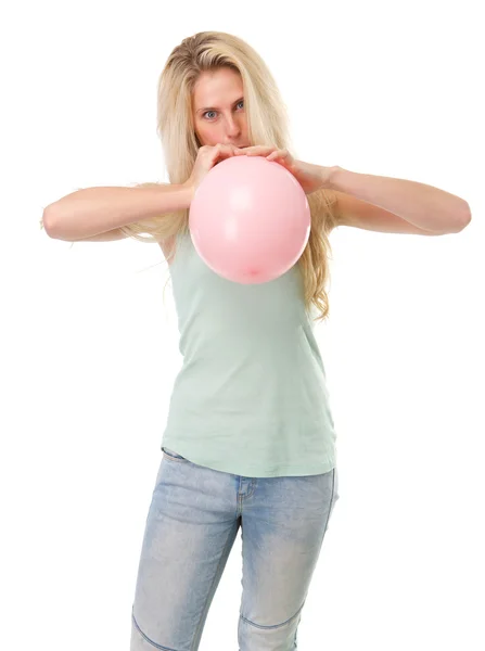 Молодая блондинка надувает воздушный шар — стоковое фото