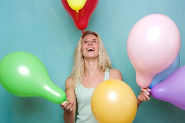 Glückliche junge blonde Frau spielt mit Luftballons — Stockfoto