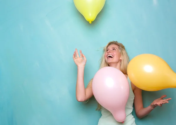 Jeune femme souriant et jouant avec des ballons — Photo