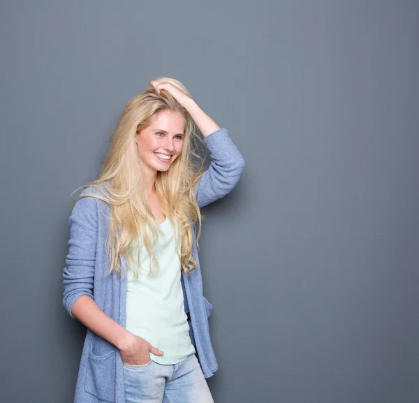 Jeune femme souriant avec la main dans les cheveux — Photo