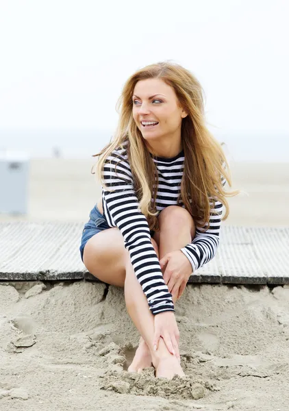 Młoda kobieta uśmiechając się na plaży — Zdjęcie stockowe