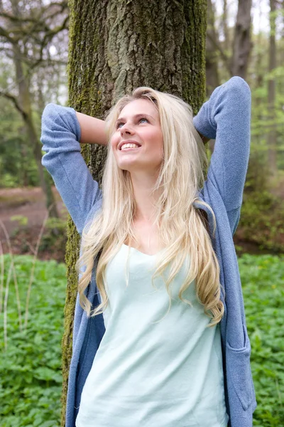 Beautiful young woman leaning on tree — Stock Photo, Image