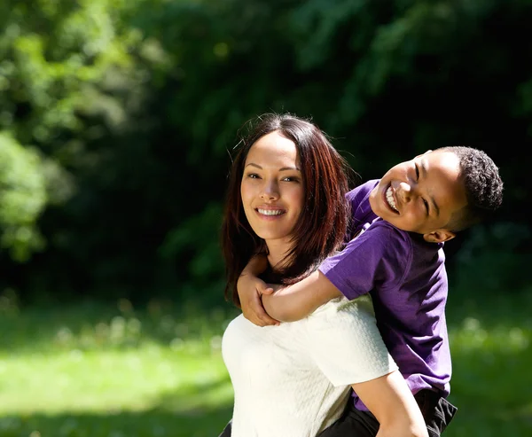 Mamma med son njuter piggyback ride — Stockfoto