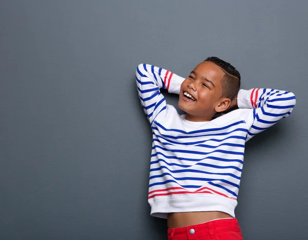 Young boy smiling with arms behind head — Stock Photo, Image