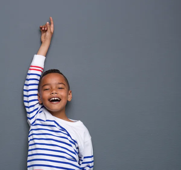 Young boy smiling with arm raised — Stock Photo, Image