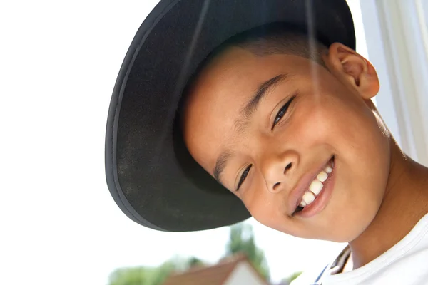 Söt liten pojke leende med svart hatt — Stockfoto