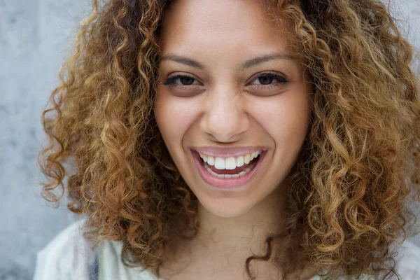 Молодая женщина с кудрявыми волосами смеется — стоковое фото