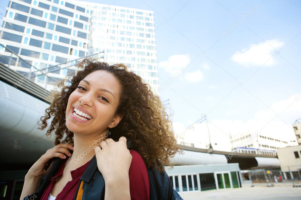 Woman smiling outdoors with backpack