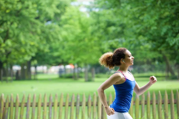 Jogging di taman dengan earphone — Stok Foto