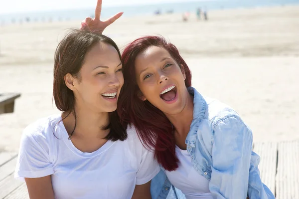 Vrolijke zusters plezier op het strand — Stockfoto