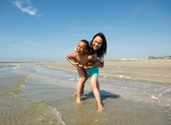 Happy mother and son playing at the beach Stock Photo