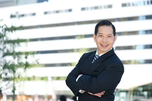 Asian business smiling with arms crossed — Stock Photo, Image