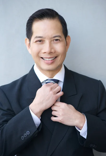 Smiling businessman holding necktie — Stock Photo, Image