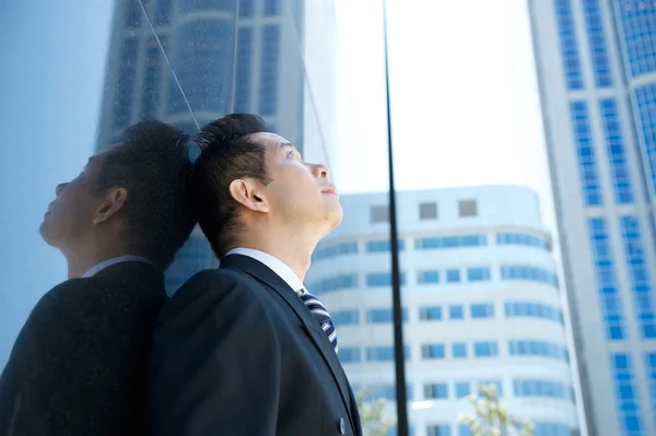 Businessman looking up at buildings — Stock Photo, Image