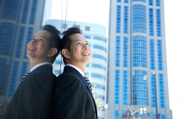 Азиатский бизнесмен улыбается в городе — стоковое фото